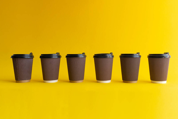 Six takeaway coffee cups with plastic covers, one cup differs from others - Φωτογραφία, εικόνα