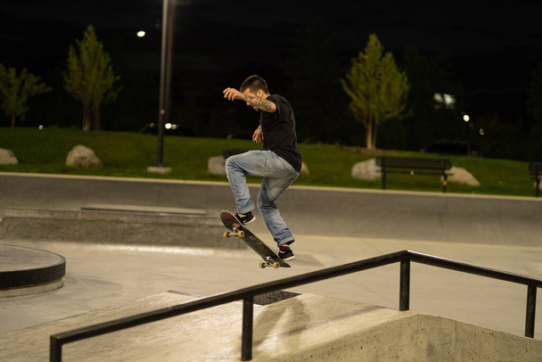 Detroit, Michigan, USA - 09.28.2019: Skaters practice their tricks in the skateboard park after dark  - Fotó, kép