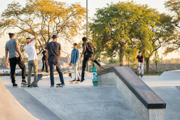 Detroit, Michigan, USA - 10.20.2019: Skaters and bikers having fun practicing in skate park at sunset in Detroit - Fotó, kép