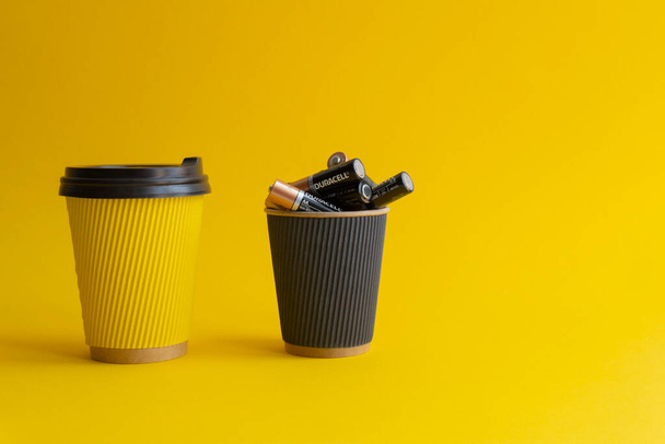 Dwie filiżanki kawy na wynos, żółte z kawą i plastikową osłoną, - Zdjęcie, obraz