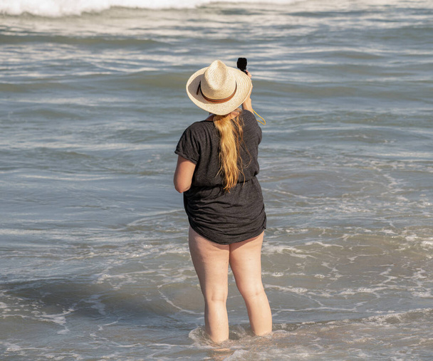 Unbekannte Frau bekommt ein szenisches Foto, während sie einen Tag am Strand verbringt - Foto, Bild