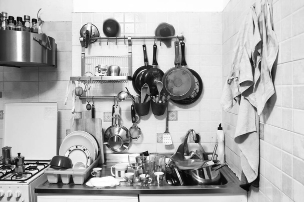 unaufgeräumte häusliche Küche, Schwarz-Weiß-Foto von zu erledigender Hausarbeit - Foto, Bild