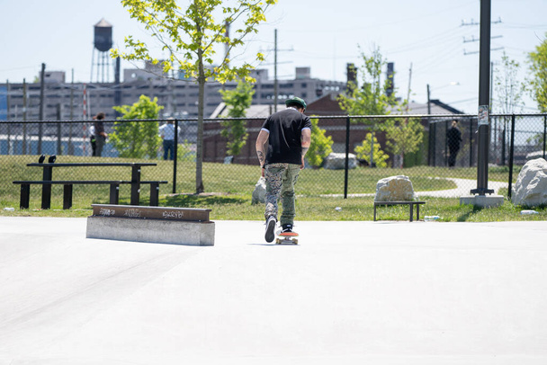 Detroit, Michigan, USA - May 31.2020: Skaters and Bikers practicing tricks at an outdoor skate park in Detroit during the Corona Virus - Photo, image