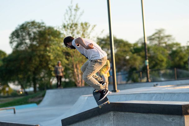 Detroit, Michigan, EUA - 07.14.2019: Os patinadores estão praticando seus truques ao pôr-do-sol no parque de skate em Detroit
 - Foto, Imagem