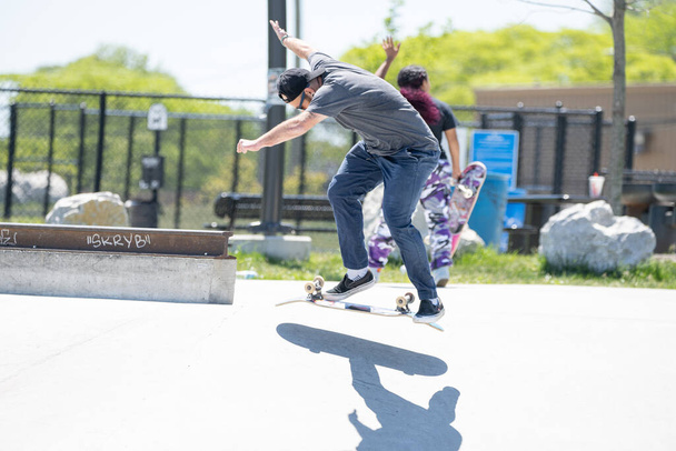 Detroit, Michigan, USA - May 31.2020: Skaters and Bikers practicing tricks at an outdoor skate park in Detroit during the Corona Virus - Foto, imagen