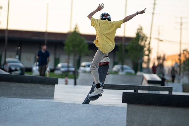 Detroit, Michigan, USA - 07.14.2019: Skatery ćwiczą swoje sztuczki o zachodzie słońca w skateparku w Detroit - Zdjęcie, obraz
