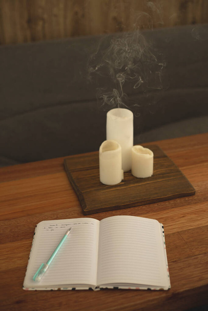 Ноутбук для записей дневника на столе со свечами
. - Фото, изображение