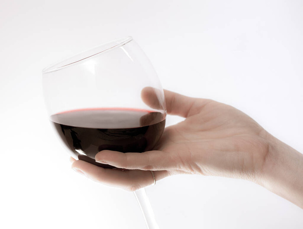χέρι κρατώντας ένα ποτήρι κόκκινο κρασί - Φωτογραφία, εικόνα