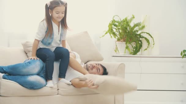 4k slowmotion video where girl is sitting on his sleepy father. - Video, Çekim