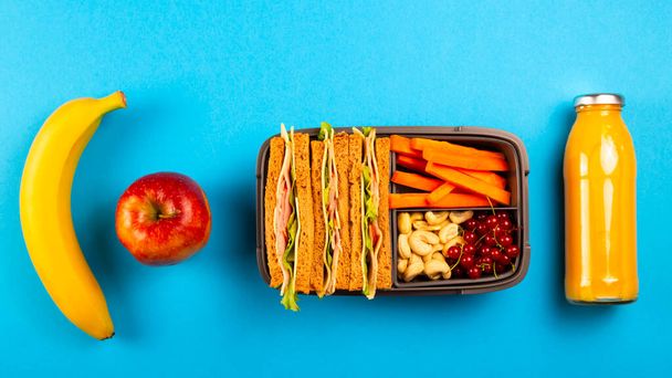 Açık mavi arka planda uygun bir konteynırda sağlıklı bir okul yemeği.. - Fotoğraf, Görsel