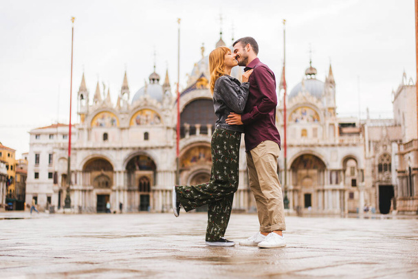 Beatiful young couple having fun while visiting Venice - Tourists travelling in Italy and sightseeing the most relevant landmarks of Venezia - Concepts about lifestyle, travel, tourism - Foto, afbeelding
