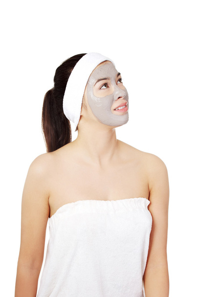 Beautiful woman with clay facial mask - 写真・画像