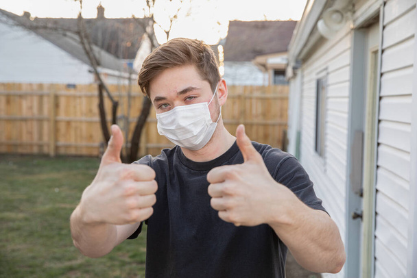十代の男の子身に着けていますA保護呼吸マスクからウイルスCOVID-19. - 写真・画像