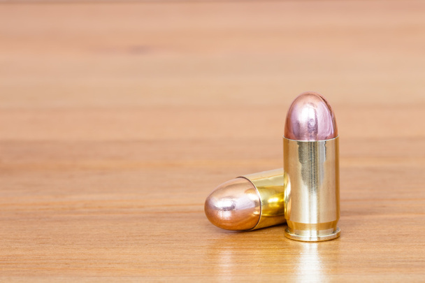9 mm or .357 bullet on wooden background - Photo, Image
