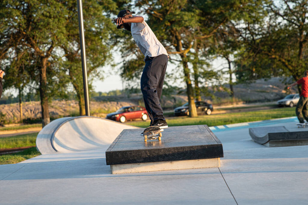 Detroit, Michigan, USA - 07.14.2019: Skaters are practicing their tricks at sunset in the skate park in Detroit - Foto, afbeelding