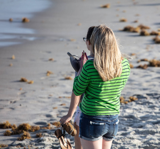 girl with a backpack on the beach - Фото, зображення