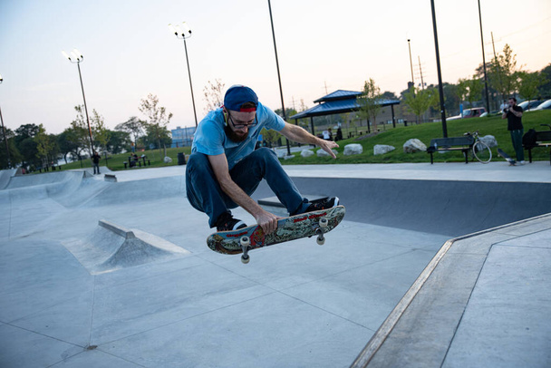 Detroit, Michigan, USA - 09.30.2019: Skateři cvičí triky při západu slunce v skate parku v Detroitu. - Fotografie, Obrázek