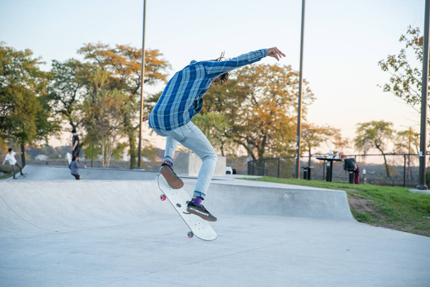 Detroit, Michigan, USA - 10.20.2019: Skaters and bikers practice tricks in Detroit as the sun goes down. - Foto, imagen