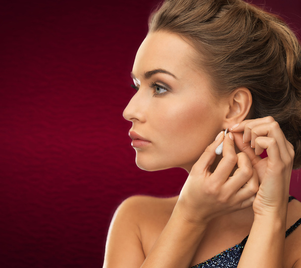 Woman wearing shiny diamond earrings - Fotoğraf, Görsel