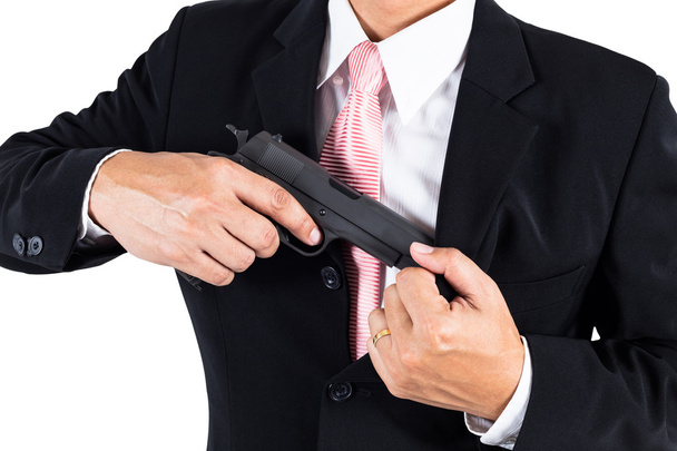 Бизнесмен вытаскивает пистолет из куртки для агрессии
 - Фото, изображение