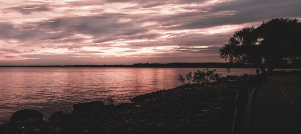 vibrant sunset reflects on a chilly shoreline - Foto, Imagen