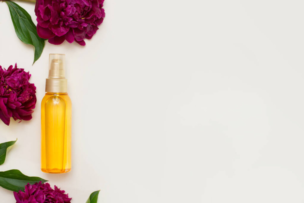 Violette Blumen mit Aromatherapie ätherisches Öl Glasflasche auf weißem Hintergrund mit einem Kopierraum - Foto, Bild