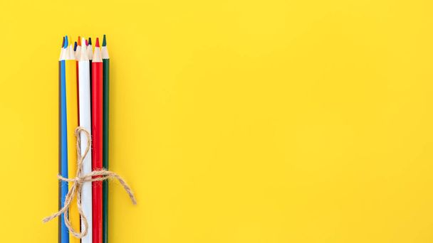 Vzdělání a zpátky do školy. Barevné tužky na žlutém pozadí s prostorem pro text. - Fotografie, Obrázek