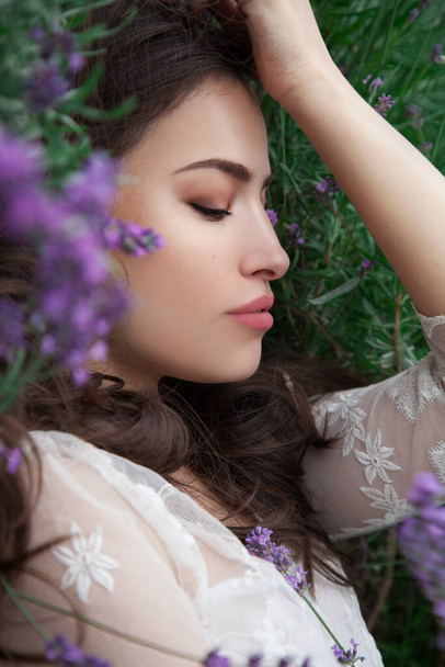 pretty young woman lying in lavender field, outdoor beauty portrait - Photo, Image