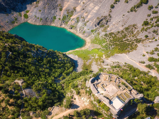 Vista aérea do Lago Azul de Imotski (Modro jezero) na cratera calcária e na fortaleza medieval de Topana. Natureza paisagem de verão, destino turístico popular na Dalmácia, fundo de viagem ao ar livre, Croácia
 - Foto, Imagem