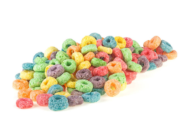 Pile of sweetened corn cereals isolated on a white background. Delicious and nutritious fruit cereal loops. Colorful corn rings. Kids breakfast. - Valokuva, kuva