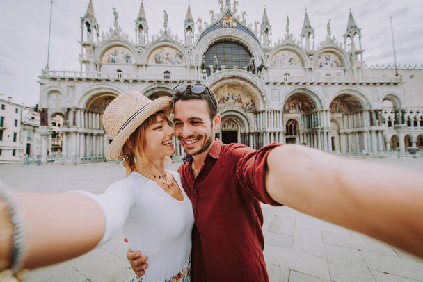 Beatiful young couple having fun while visiting Venice - Tourists travelling in Italy and sightseeing the most relevant landmarks of Venezia - Concepts about lifestyle, travel, tourism - Foto, Imagem