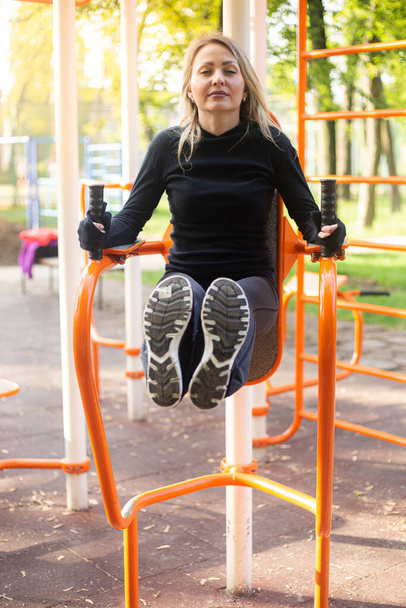 The girl on the summer playground Doing Sit Ups. Healthy lifestyle. - Photo, image
