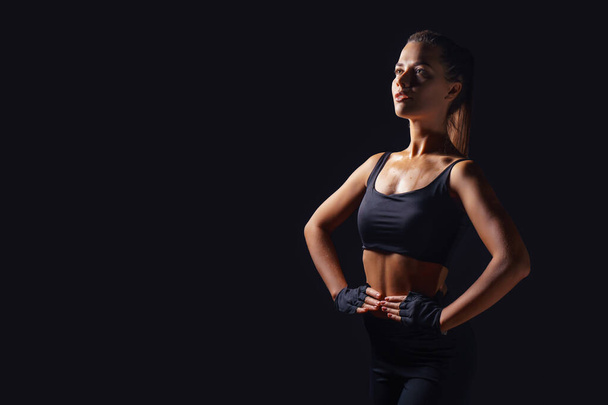 Seksowna wysportowana kobieta fitness. Czarne tło - Zdjęcie, obraz