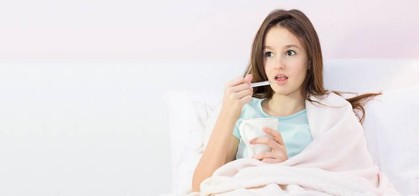 Chica adolescente acostada en la cama con fiebre alta
 - Foto, Imagen