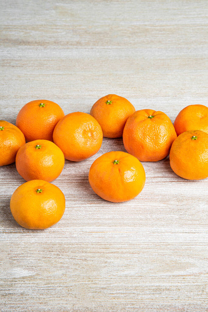 Μια ομάδα από φρέσκα πορτοκάλια όμορφα τοποθετημένα σε ένα λευκό ζωγραφισμένο ξύλο πίνακα υφή. - Φωτογραφία, εικόνα