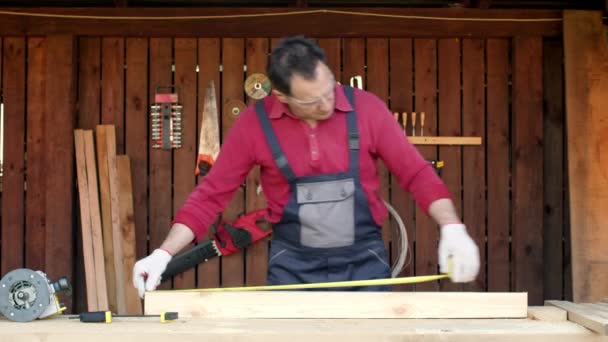 El carpintero en el taller marca los detalles de los muebles con la cinta métrica
 - Metraje, vídeo