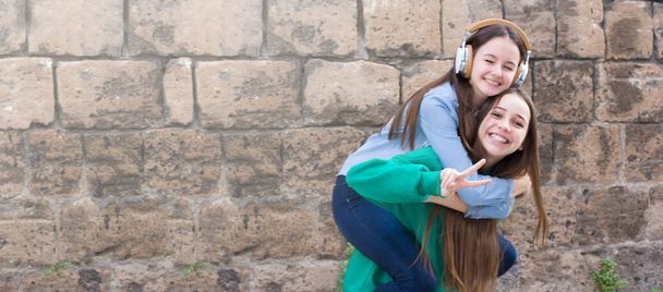 Dospívající dívky se baví na starých cihel zeď pozadí - Fotografie, Obrázek