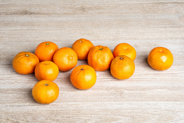 Bir grup taze portakal, beyaz desenli ahşap panoda ustalıkla düzenlenmiş.. - Fotoğraf, Görsel