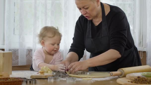 Babcia cięcia ciasteczka z surowego piernika ciasto z cute wnuczka - Materiał filmowy, wideo