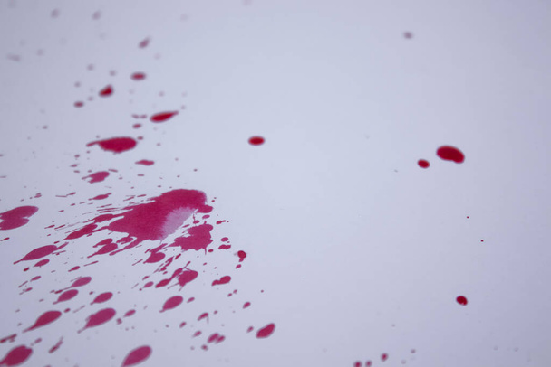 drops of red liquid - blood - on a white paper. Copy space - Photo, image