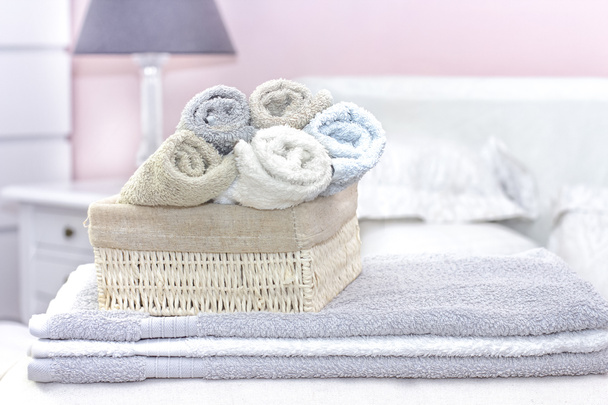 Стек рушників для ванни на прикрасі ліжка в інтер'єрі спальні
 - Фото, зображення