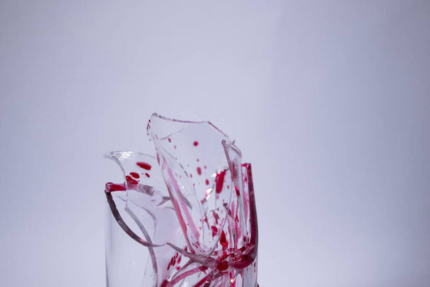 gouttes de sang liquide rouge- sur les fragments d'un verre cassé sur un fond blanc. Isolé. Espace de copie. concept de douleur - Photo, image
