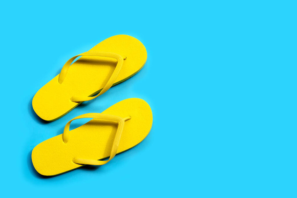 Yellow flip flops on blue background. Copy space - Photo, image