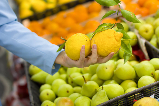 Nainen käsi valita sitruunat supermarketissa - Valokuva, kuva
