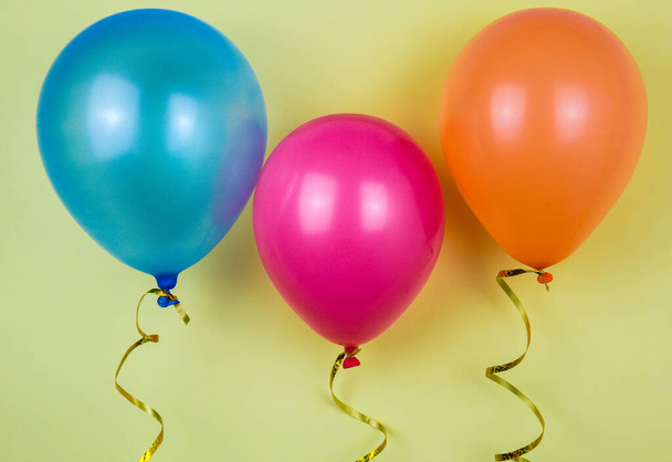 Διαφορετικά χρώματα μπαλονιών. Μπαλόνια σε κίτρινο φόντο - Φωτογραφία, εικόνα