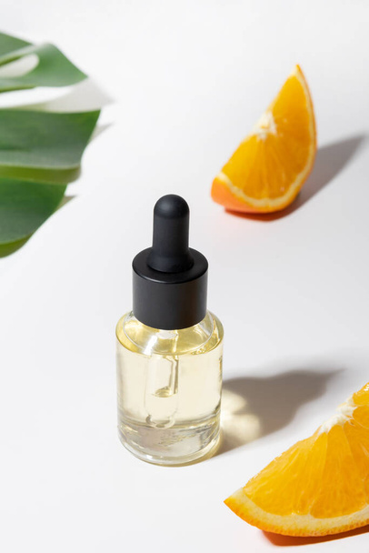Cosmetic hyaluronic acid or hydrating oil and orange essence on white background. Close up. Anti cellulite care. - Zdjęcie, obraz