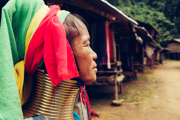 Hosszú nyak portréja Nő szövött ruhát a háza előtt törzsi faluban Észak-Thaiföldön. - Fotó, kép