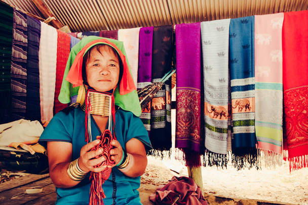 Dlouhý krk žena tkaní látky před svým domem v kmenové vesnici Severní Thajsko. - Fotografie, Obrázek