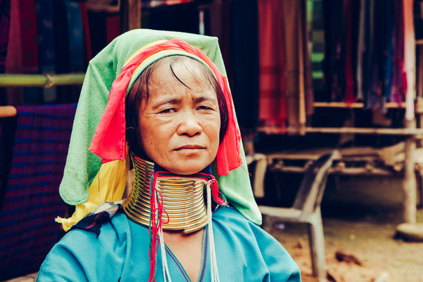 Portrait of Long Neck Woman weave cloth in front her house in tribal village Northern Thailand. - Photo, Image