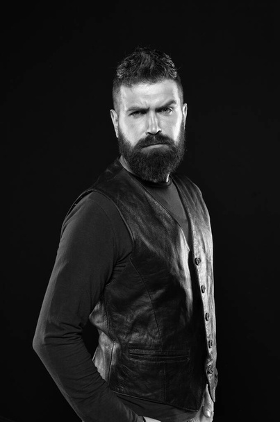 Man confident and brutal style black background. Handsome face. Man with beard in black leather clothes. Barbershop concept. Grow mustache. Fashion model. Strict mature face. Facial hair. Male face - Photo, Image